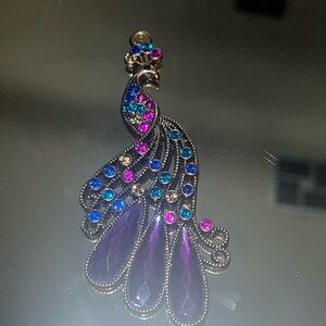 This is a bronze metal Peacock pendant, with green purple and yellow stones